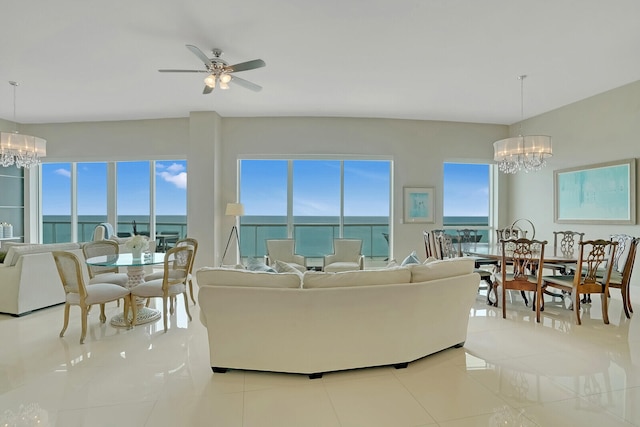 tiled living room with a water view and ceiling fan with notable chandelier