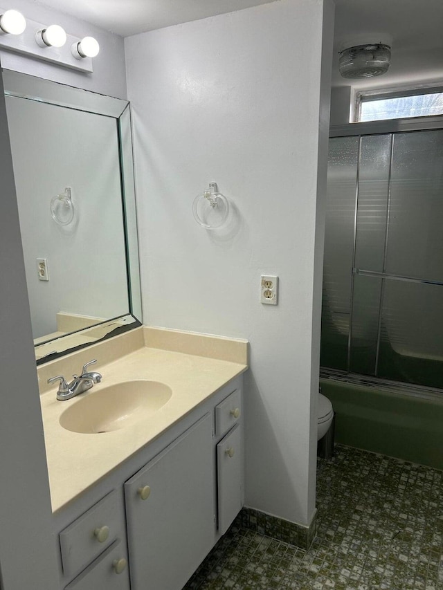 full bathroom with vanity, toilet, and shower / bath combination with glass door