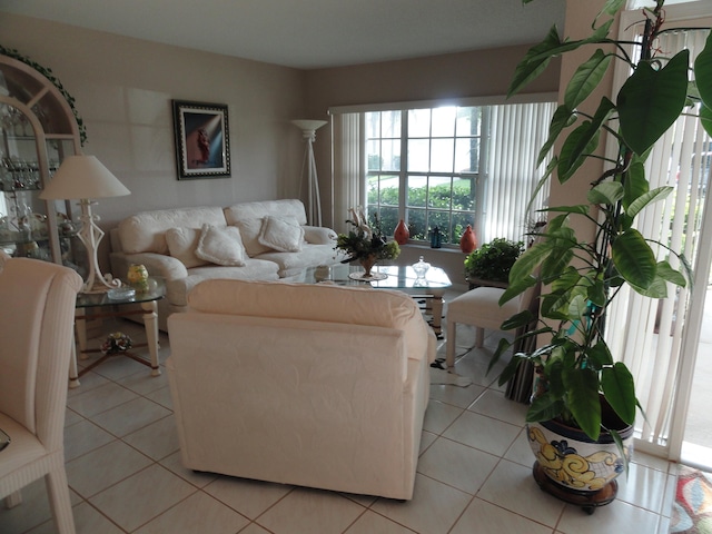 living room with decorative columns and light tile patterned floors