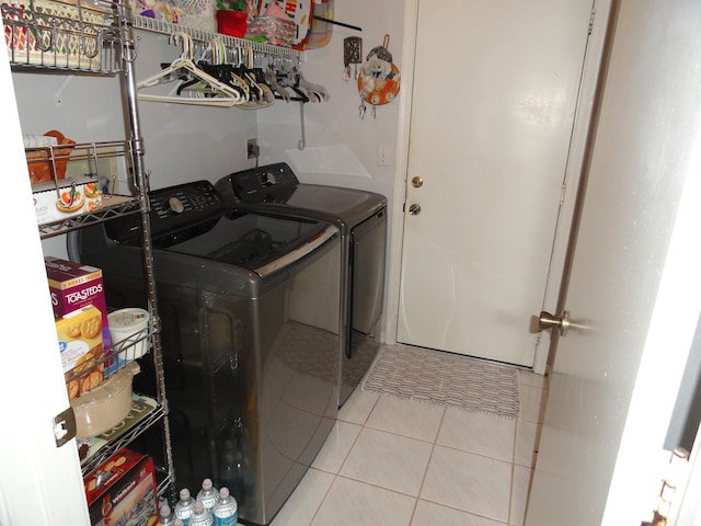 laundry area featuring washer and clothes dryer and light tile patterned floors