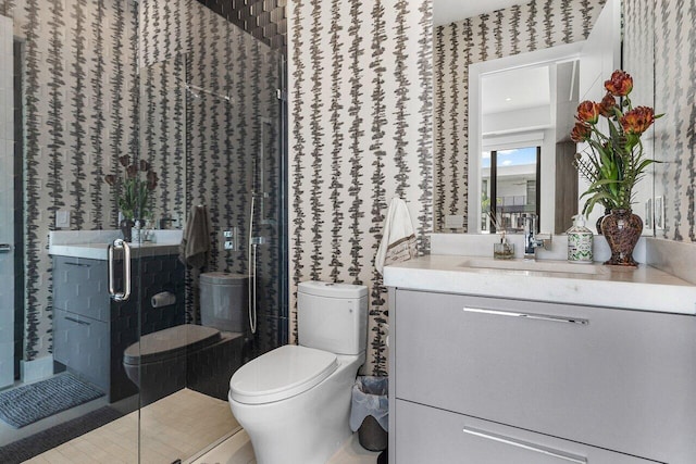 bathroom with toilet, vanity, and a shower with door