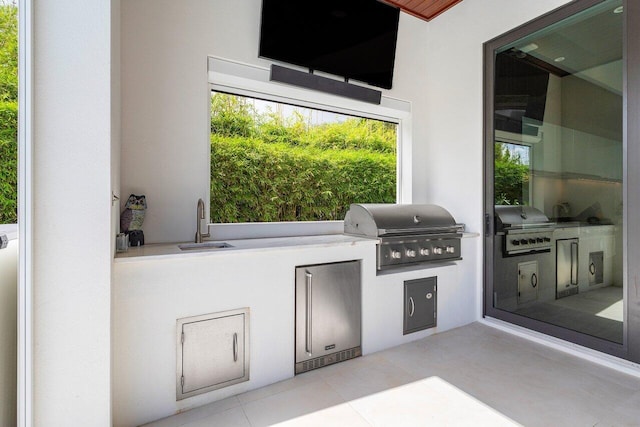 view of patio / terrace featuring exterior kitchen, sink, and a grill