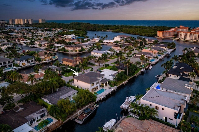 aerial view at dusk featuring a water view