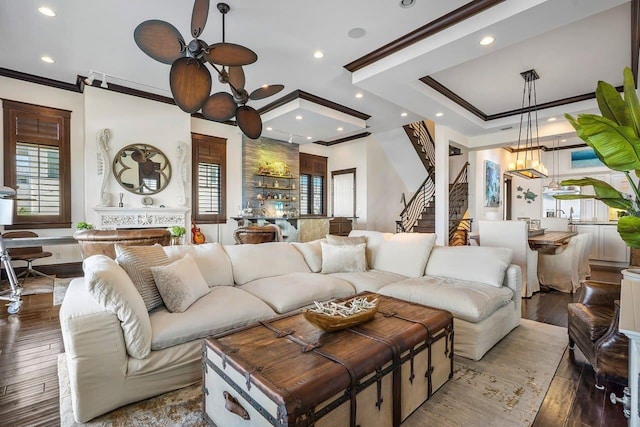 living room with a large fireplace, ceiling fan, crown molding, and hardwood / wood-style flooring