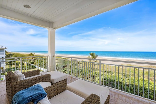 balcony featuring a water view and a beach view