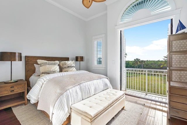 bedroom featuring multiple windows, ornamental molding, wood-type flooring, and access to exterior