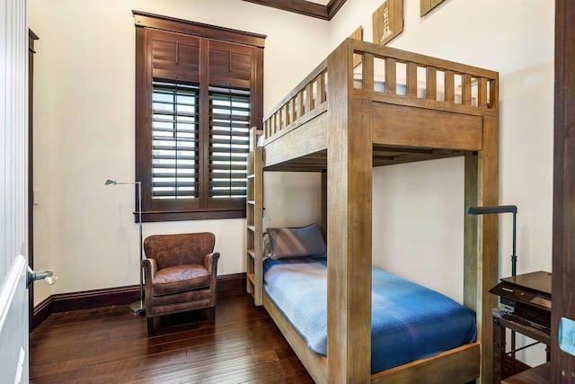 bedroom featuring crown molding and dark wood-type flooring