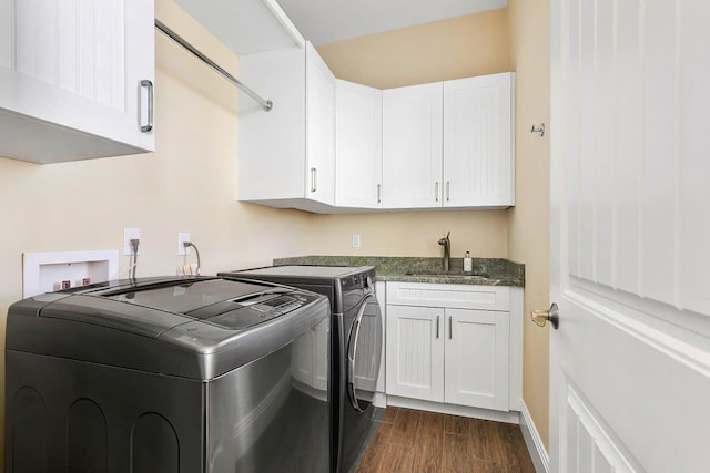 laundry area with separate washer and dryer, dark hardwood / wood-style flooring, cabinets, and sink