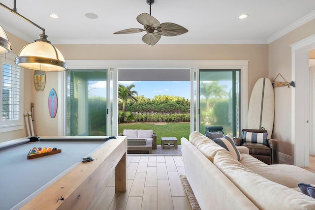 recreation room featuring plenty of natural light, light hardwood / wood-style floors, ornamental molding, and ceiling fan