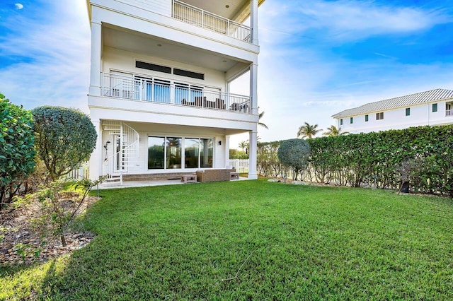 back of property with a yard and a patio area