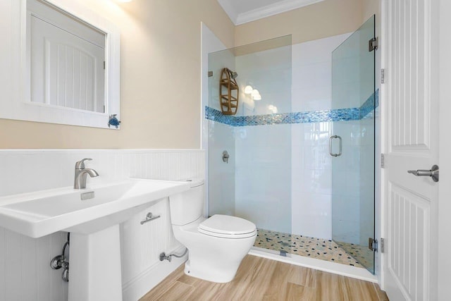 bathroom featuring hardwood / wood-style flooring, toilet, ornamental molding, and walk in shower