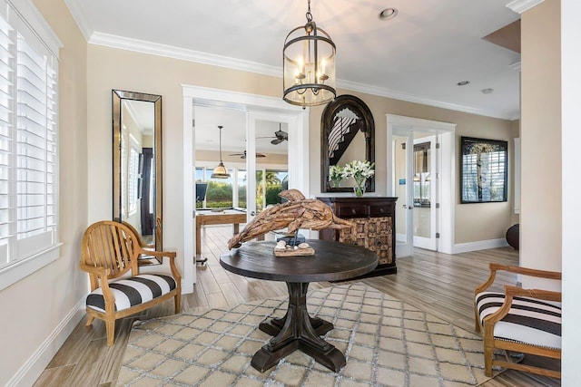 living area with wood-type flooring, crown molding, and a chandelier