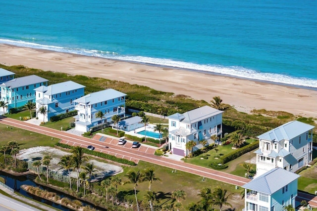 bird's eye view with a water view and a beach view