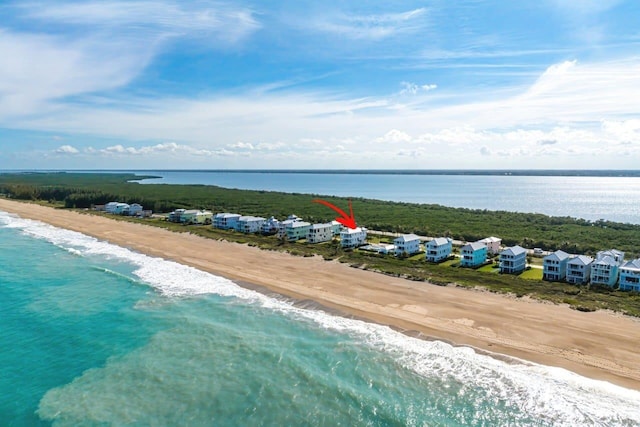 birds eye view of property featuring a water view and a beach view