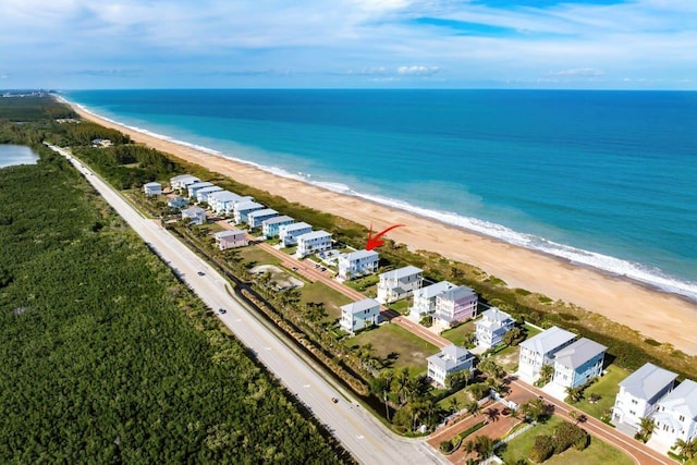 drone / aerial view with a water view and a beach view