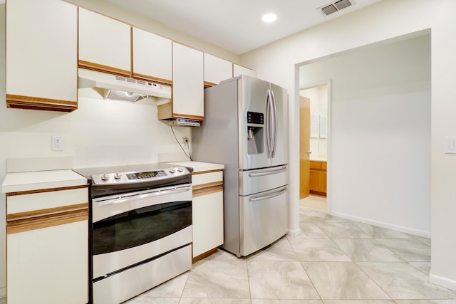 kitchen with appliances with stainless steel finishes, white cabinets, and light tile patterned floors