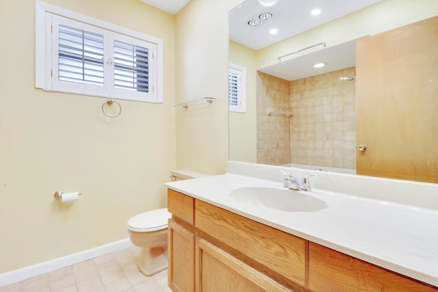 bathroom featuring vanity, a tile shower, toilet, and tile patterned flooring