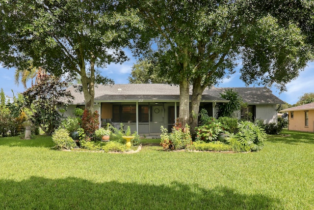 view of front facade with a front yard and a sunroom