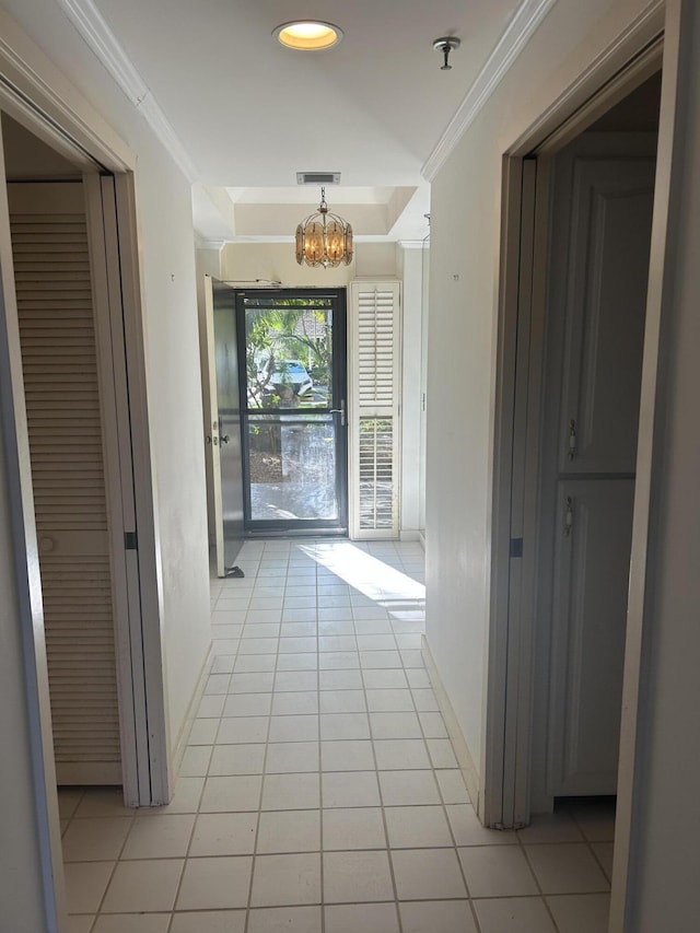 11370 Twelve Oaks Way Unit 117, North Palm Beach, FL 33408 - hall with baseboards, visible vents, a notable chandelier, light tile patterned flooring, and crown molding