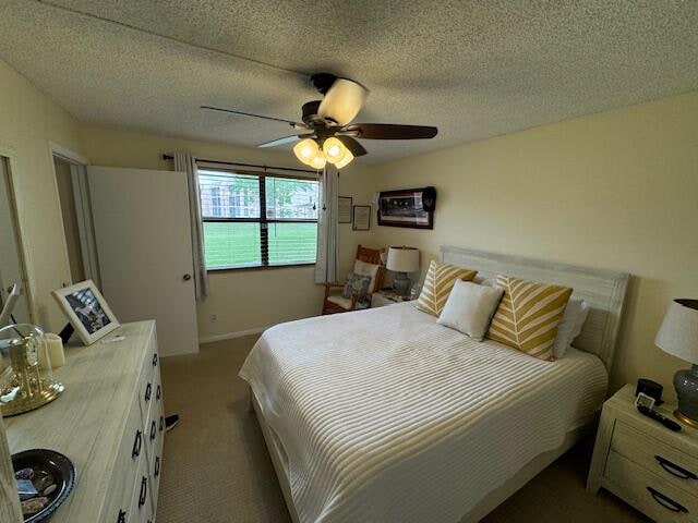 carpeted bedroom featuring a textured ceiling and ceiling fan