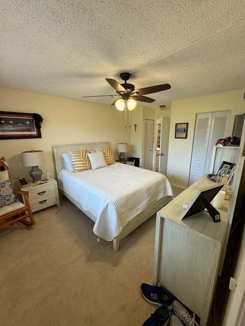 carpeted bedroom with a textured ceiling and ceiling fan