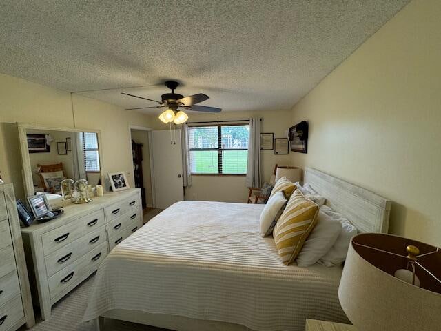 bedroom with ceiling fan and a textured ceiling