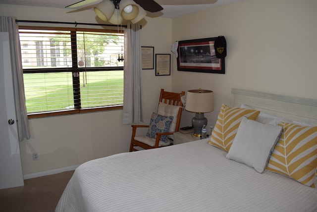 bedroom with ceiling fan, a textured ceiling, carpet flooring, and multiple windows