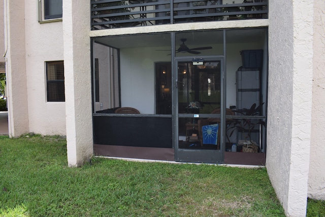 property entrance featuring a yard and ceiling fan