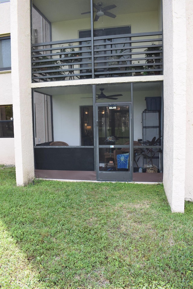 entrance to property featuring a balcony and a lawn