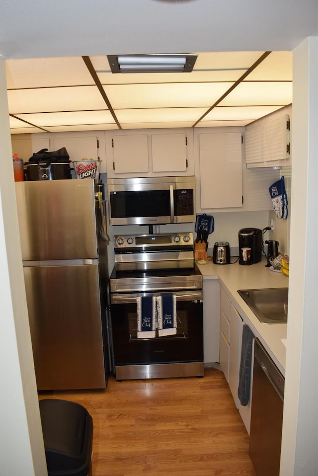 kitchen featuring light hardwood / wood-style floors, stainless steel appliances, and sink