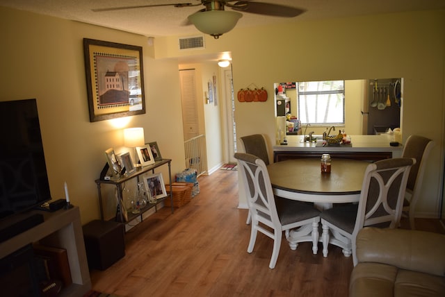 dining space featuring hardwood / wood-style floors, a textured ceiling, and ceiling fan