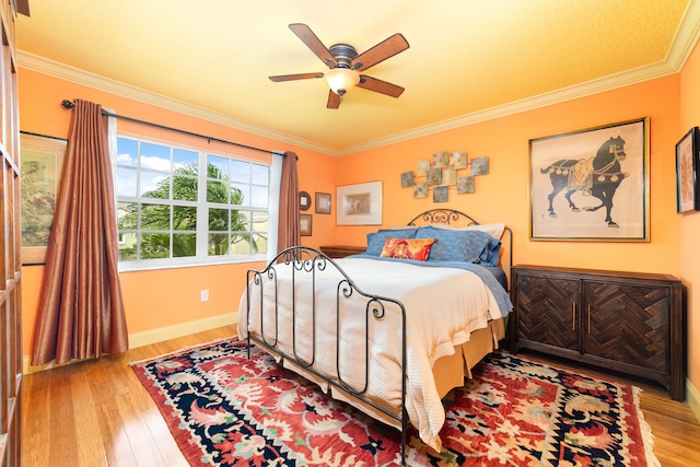 bedroom featuring light hardwood / wood-style flooring, ornamental molding, and ceiling fan