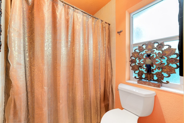 bathroom with curtained shower and toilet