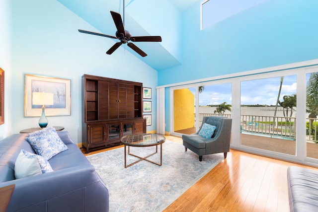 living room with light wood-type flooring, high vaulted ceiling, and ceiling fan