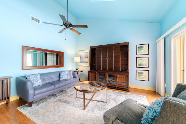 living room featuring light hardwood / wood-style flooring, high vaulted ceiling, and ceiling fan