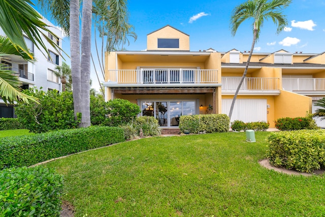 back of house with a yard and a balcony