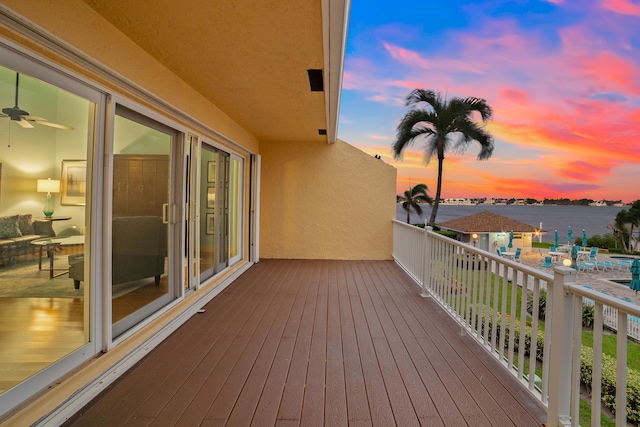 deck at dusk featuring a water view