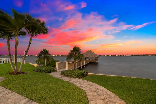 view of dock featuring a water view and a yard