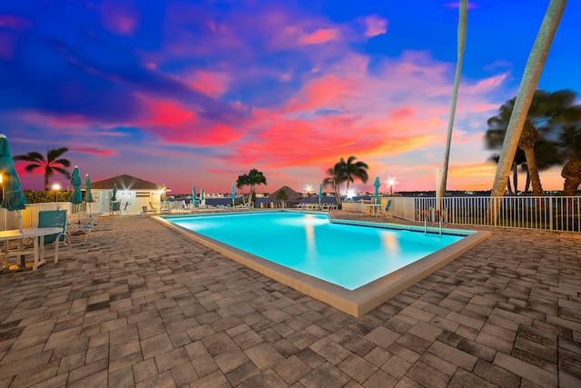 pool at dusk with a patio