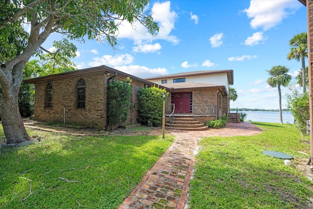 view of front of house with a front yard and a water view