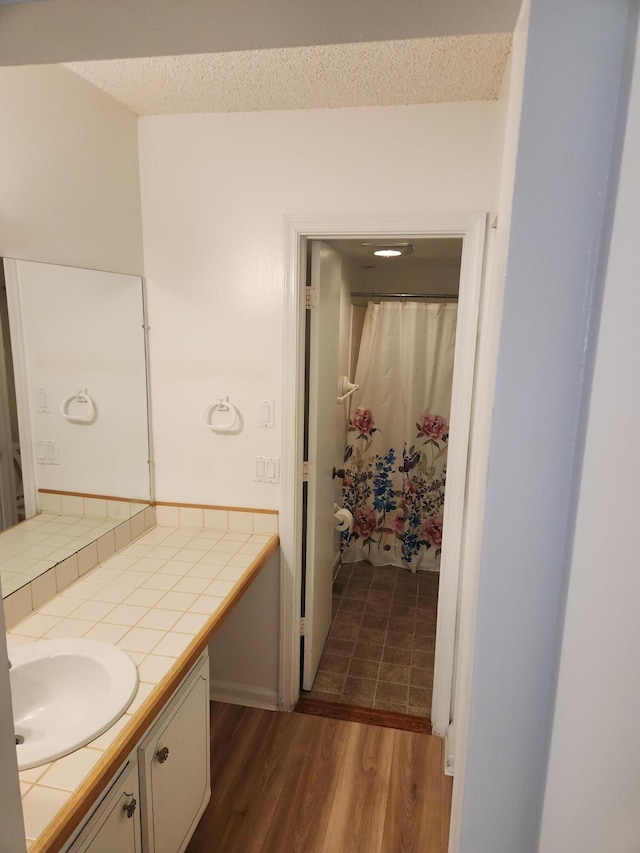 bathroom featuring hardwood / wood-style floors, a textured ceiling, and vanity