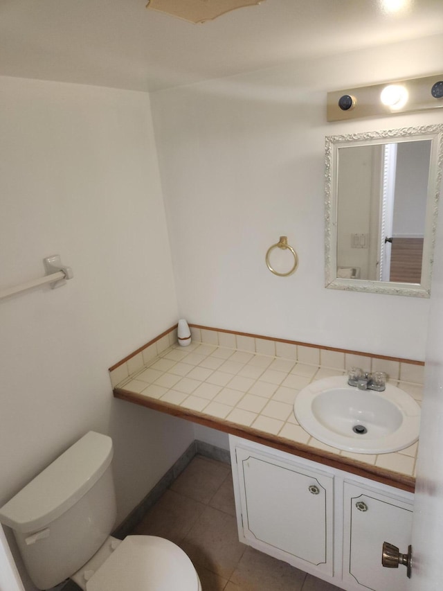 bathroom with toilet, tile patterned flooring, and vanity