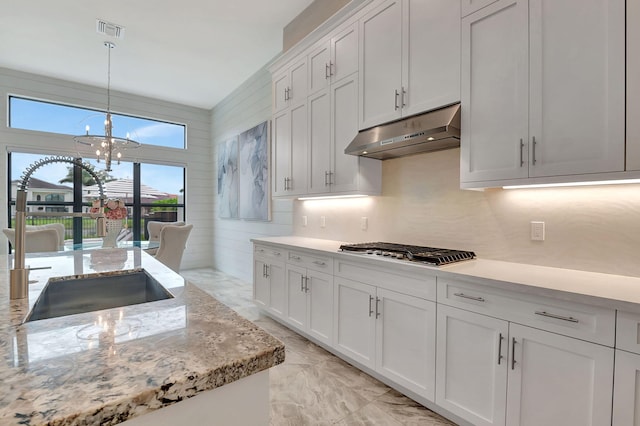 kitchen with a notable chandelier, decorative light fixtures, white cabinetry, and sink