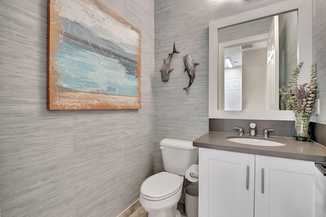 bathroom with vanity, tile walls, and toilet