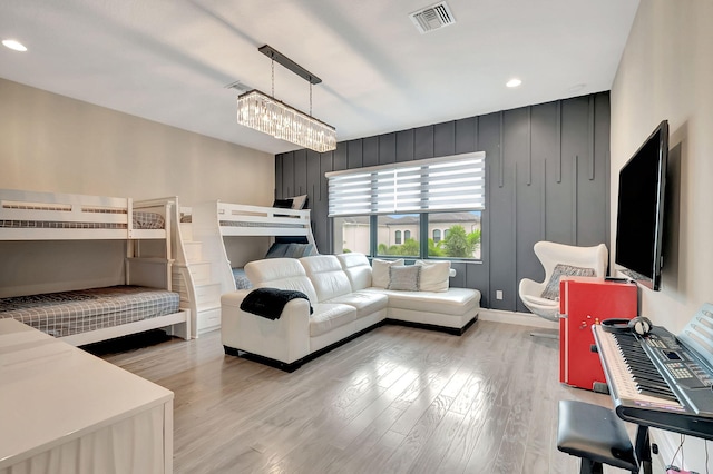 bedroom with a notable chandelier and light wood-type flooring