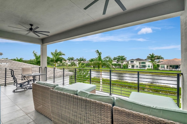 view of patio featuring ceiling fan, a balcony, and a water view