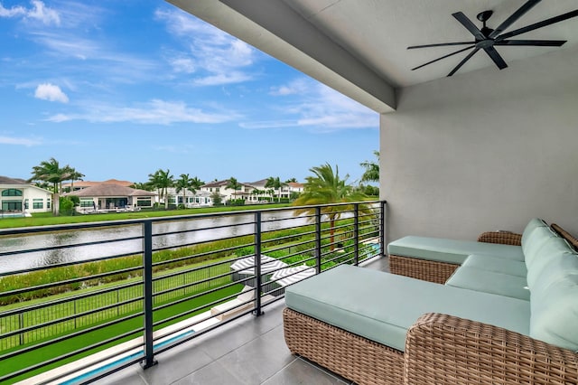 balcony featuring ceiling fan and a water view