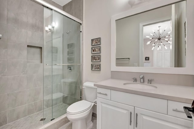 bathroom featuring tile patterned floors, vanity, toilet, and a shower with door