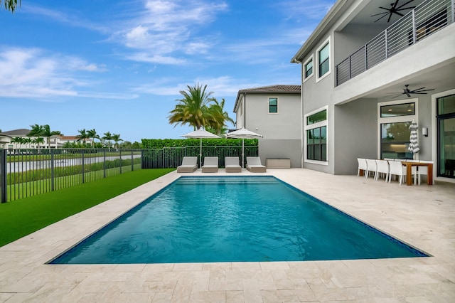 view of pool with a lawn, ceiling fan, and a patio