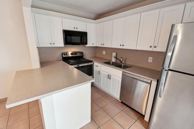 kitchen featuring white cabinetry, kitchen peninsula, stainless steel appliances, light tile patterned flooring, and sink